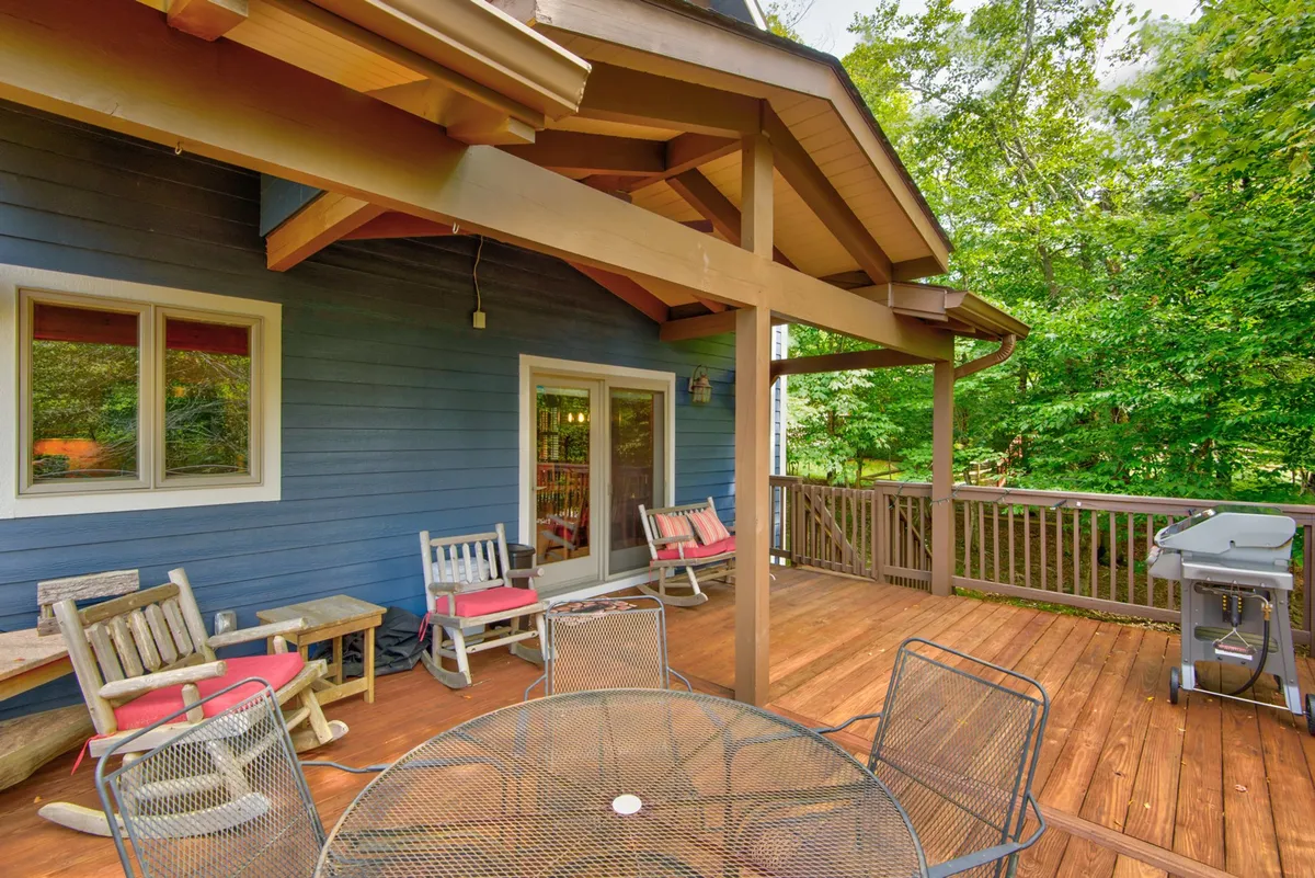 A welcoming deck scene with ample outdoor seating, a grill for barbecues, and a tranquil view of the surrounding greenery. This space is perfect for socializing, enjoying meals al fresco, or simply relaxing in the fresh air.