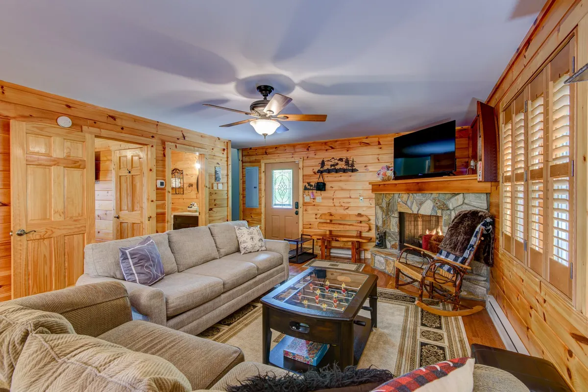 A welcoming living area with a fireplace, sofa, and coffee table, ideal for game nights, cozy evenings, or group gatherings. The ambiance is inviting and perfect for winter retreats.